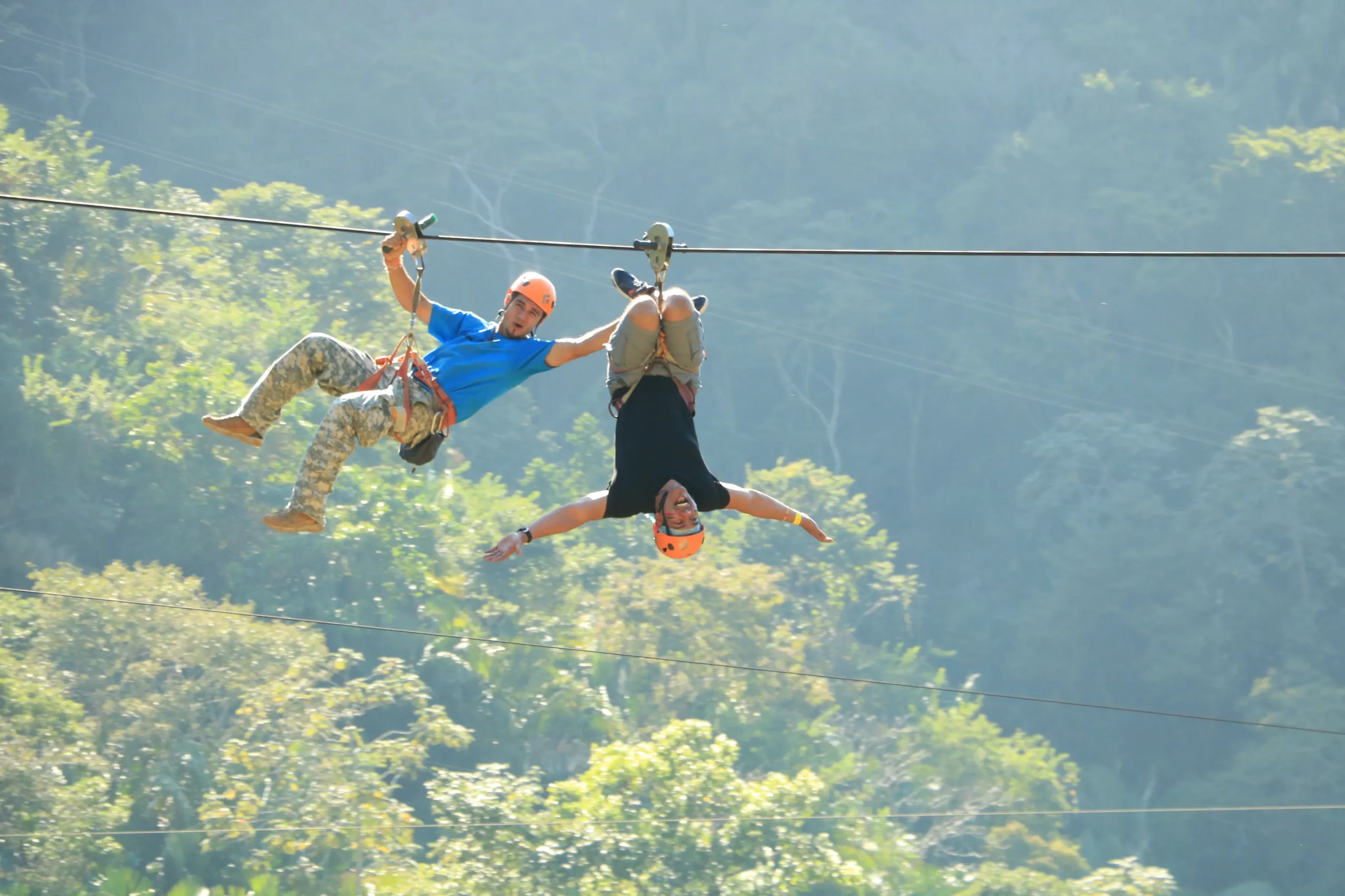 Persona deslizándose en una tirolesa suspendida sobre la selva tropical, disfrutando de vistas espectaculares, una de las things to do in Puerto Vallarta.