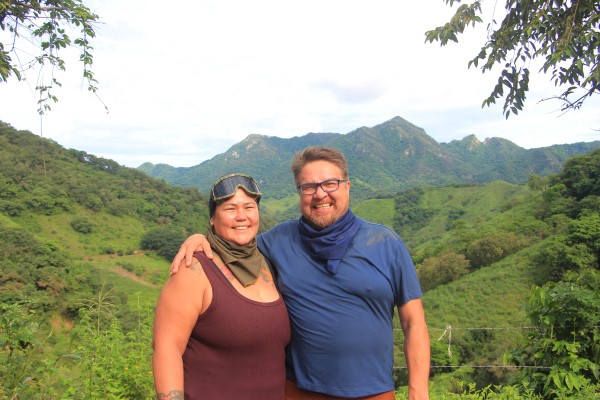 A happy couple poses at a stunning viewpoint while enjoying private tours Puerto Vallarta, combining breathtaking landscapes and special moments.