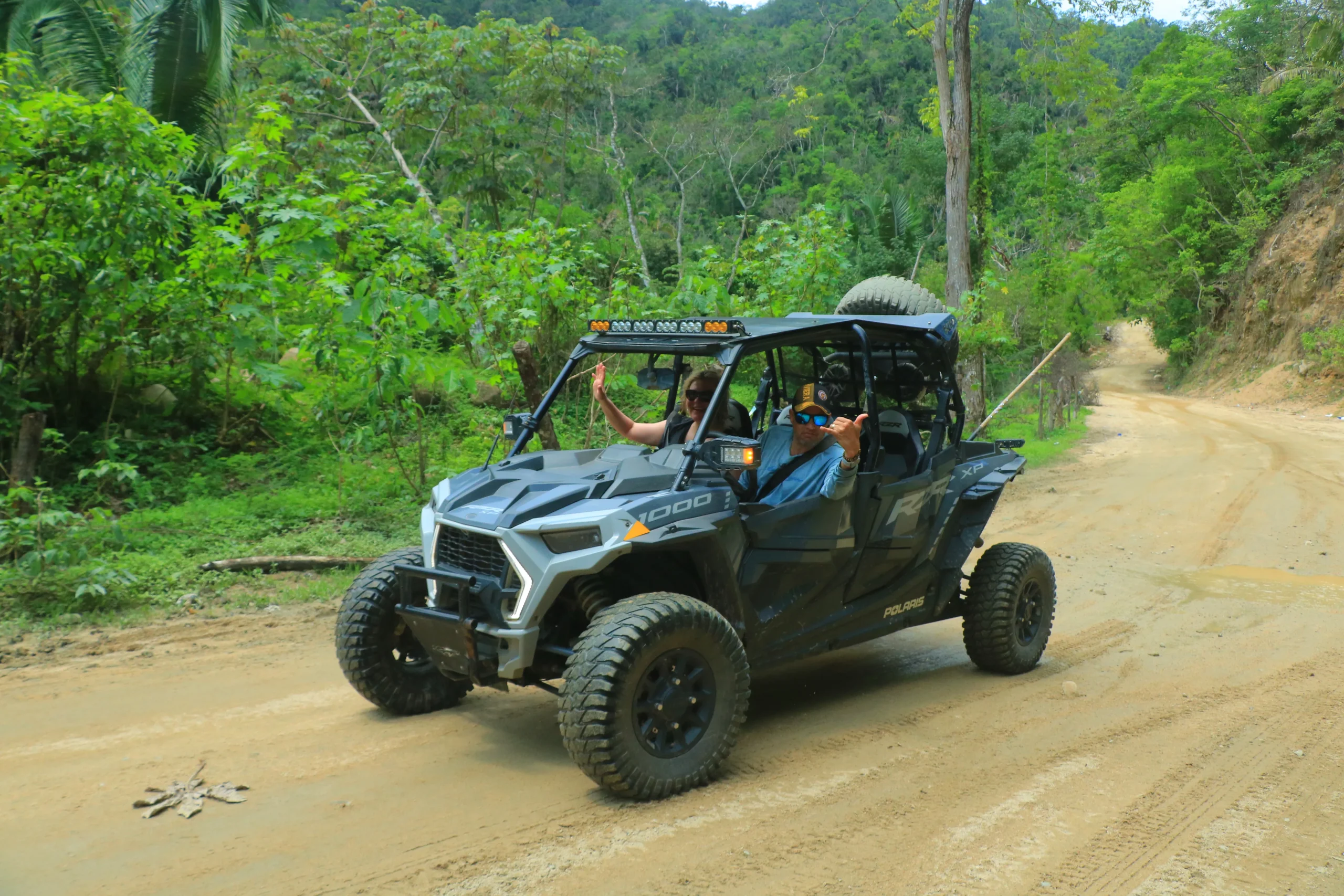 Aventurero en una RZR disfrutando de los impresionantes paisajes montañosos con la sierra como telón de fondo, en un recorrido lleno de emoción.