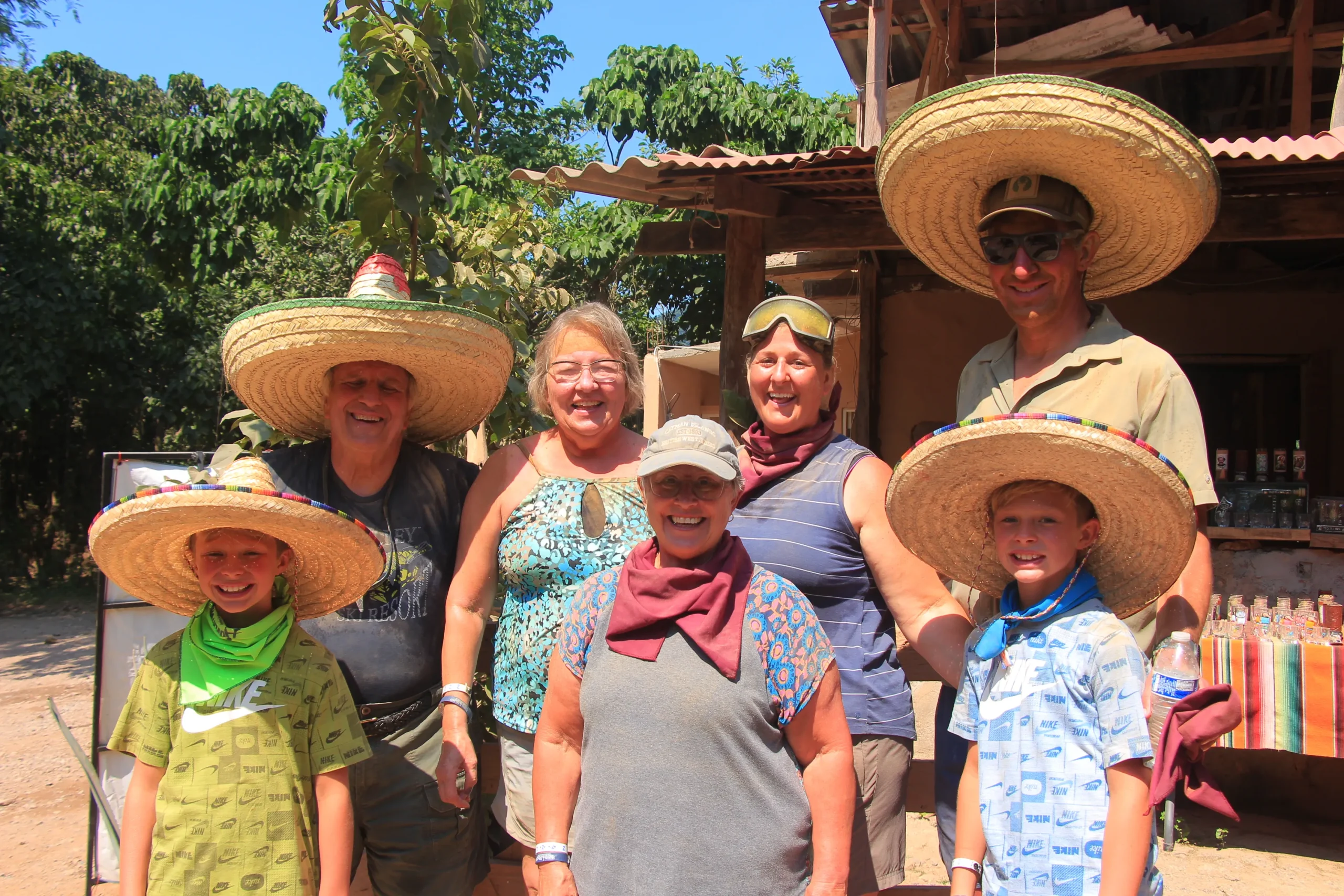 A smiling family poses for a photo on an amazing journey with private tours Puerto Vallarta, enjoying the adventure and tropical scenery.