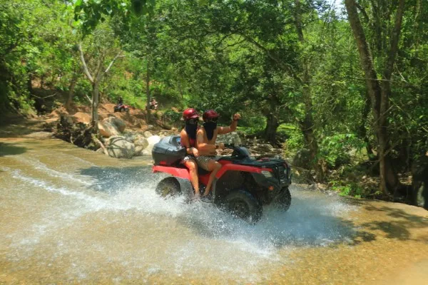 Groups of people riding ATVs on off-road trails, experiencing the excitement of Puerto Vallarta’s rugged terrains.