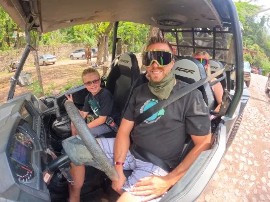 Father and son enjoying an RZR ride during an exciting excursion in Puerto Vallarta, surrounded by nature.