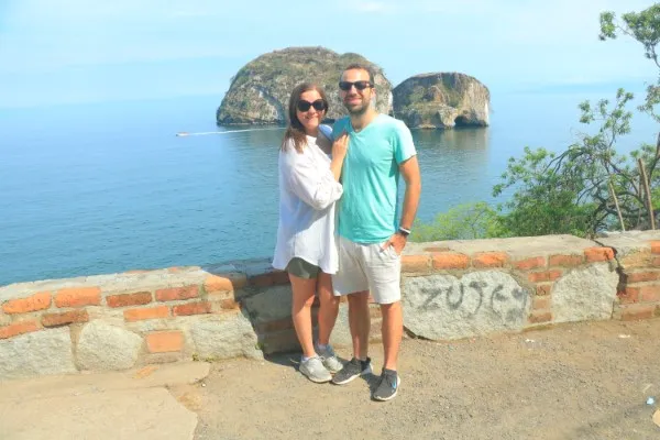 A couple walks along the shore at sunset, hand in hand, enjoying one of the most romantic things to do in Puerto Vallarta during their getaway