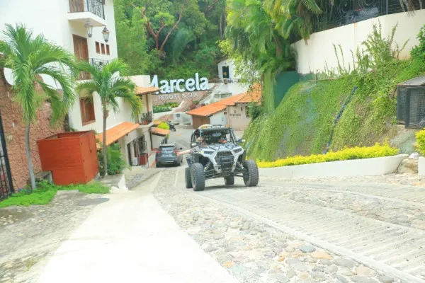 A rzr vehicle rolls down a cobblestone street in a colorful local village as part of an authentic cultural activity from the things to do in Puerto Vallarta