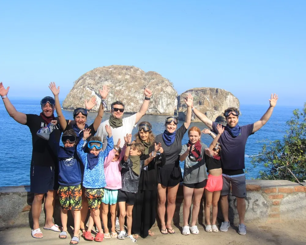 A group of people gathers by the sea after enjoying various extreme activities in nature.