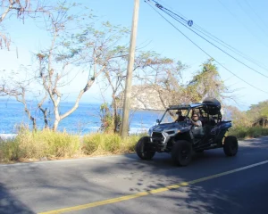 A RZR vehicle moves along the coastal road as part of the extreme activities during the tour.