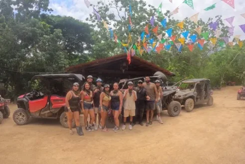 A Group Of Travelers Gathers Before Starting Their Route, Surrounded By Colorful Flags And Ready For A Day Of ATV And RZR Adventures.