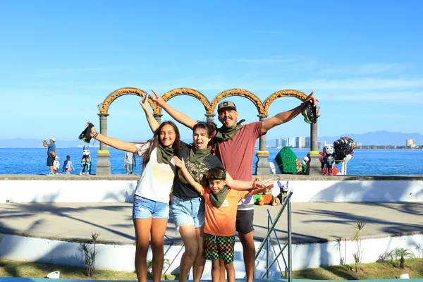 A smiling family poses together for a photograph during a boat ride in Puerto Vallarta, showcasing joy, togetherness, and special memories.